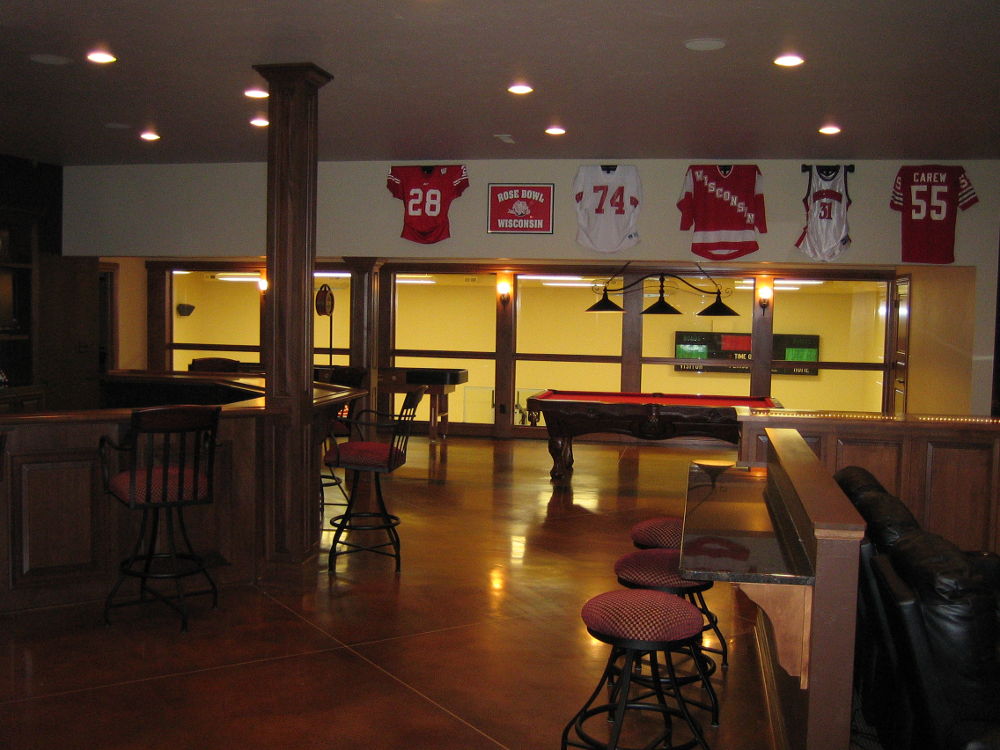 Basement sports bar lounge with brown concrete floor